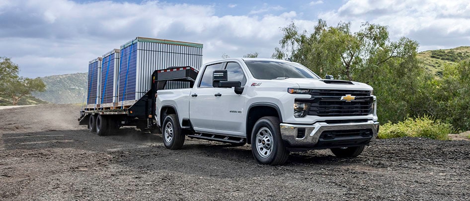 Un véhicule Chevrolet qui tire une remorque sur une route de terre.