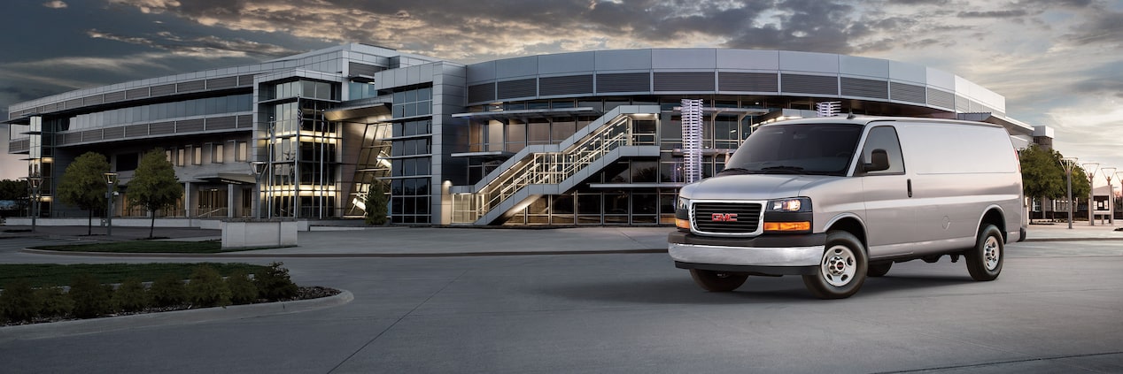 A Chevrolet Express Cargo Van parked outside a building.