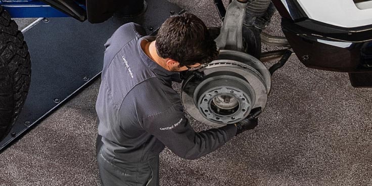 A Car Mechanic replacing the wheels of a GM Fleet vehicle.