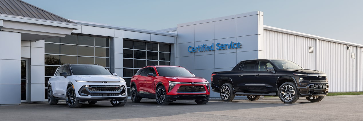 Three GM Fleet vehicles parked outside a building.