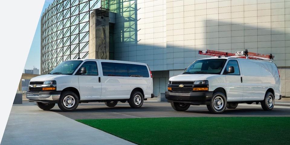 Two GM Fleet vehicles parked outside a building on a sunny day.