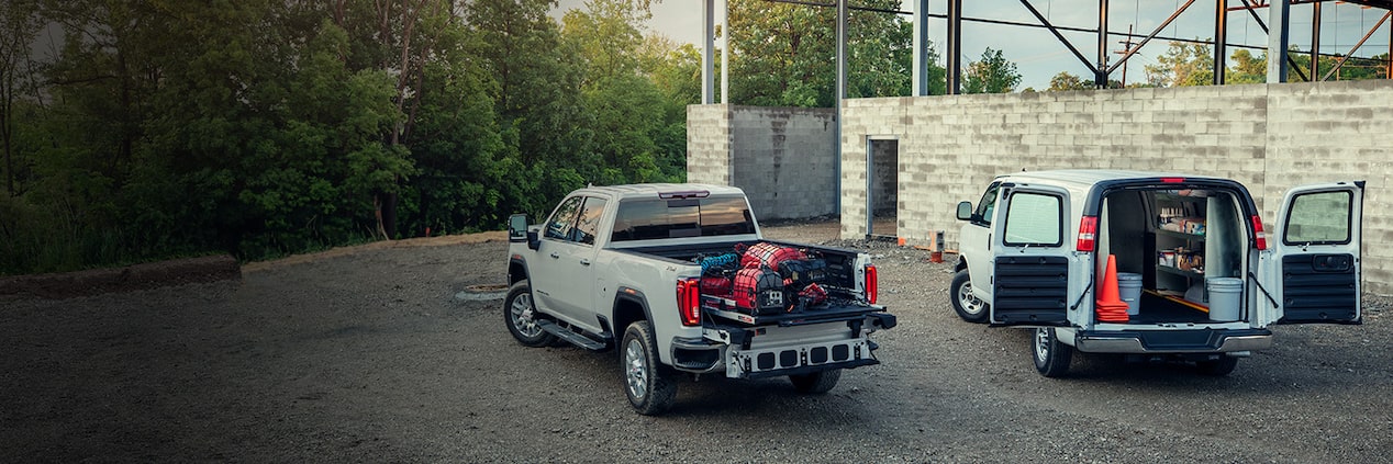 Deux camions Parcs GM stationnés sur un chantier.