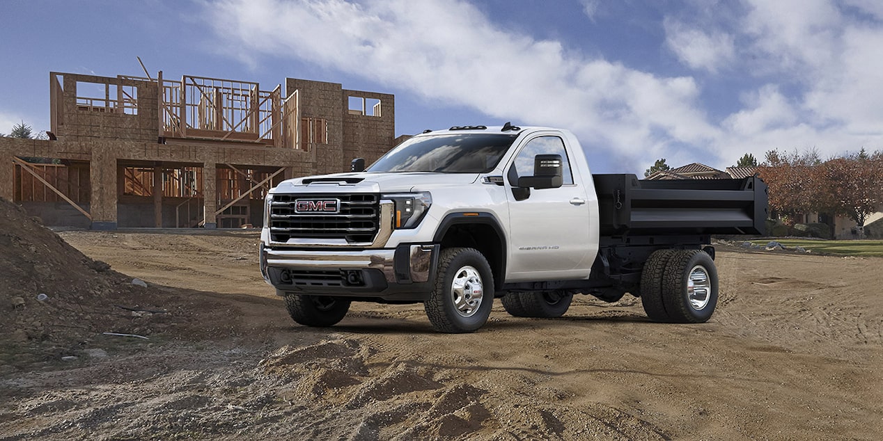 Un camion de travail GMC stationné près d’un chantier.