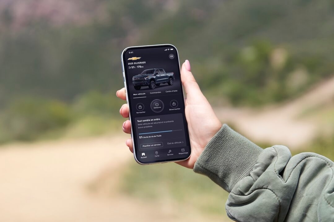 Une personne accédant à des informations liées à OnStar via un téléphone mobile.