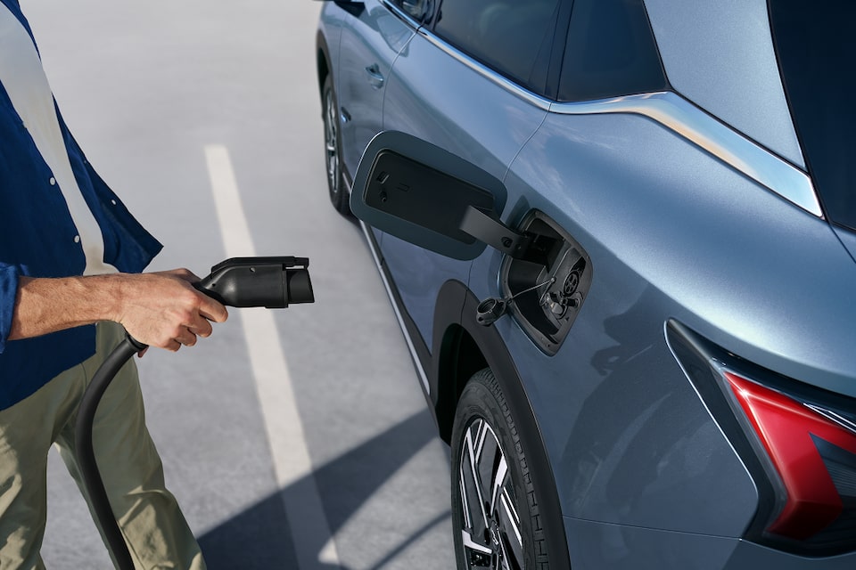 Homme qui branche un véhicule électrique.