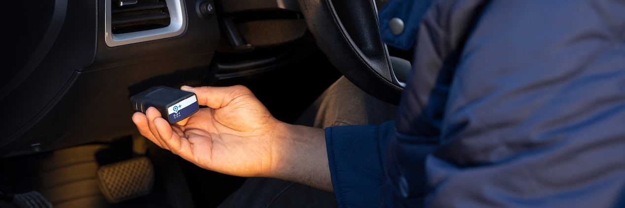 Une personne tient l’adaptateur parc OnStar.