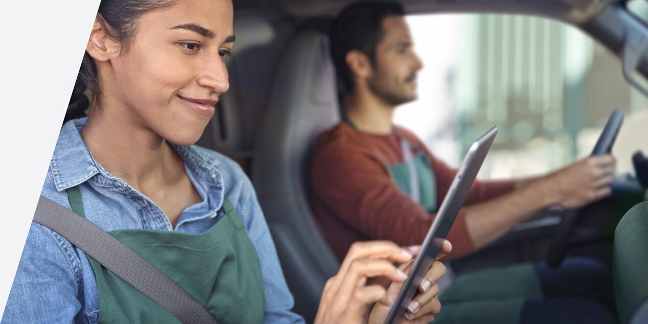 A person using a mobile device while seated inside a GM Fleet vehicle.