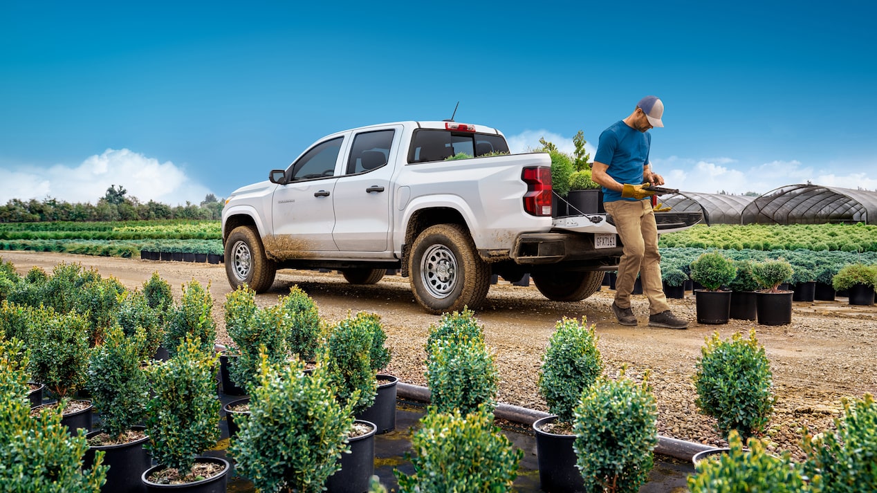 Une personne s’appuie sur la benne d’un camion GM Envolve.