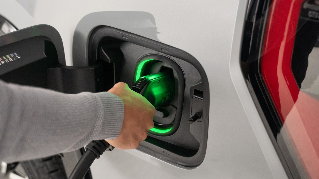 Une personne rechargeant un véhicule Parcs GM.