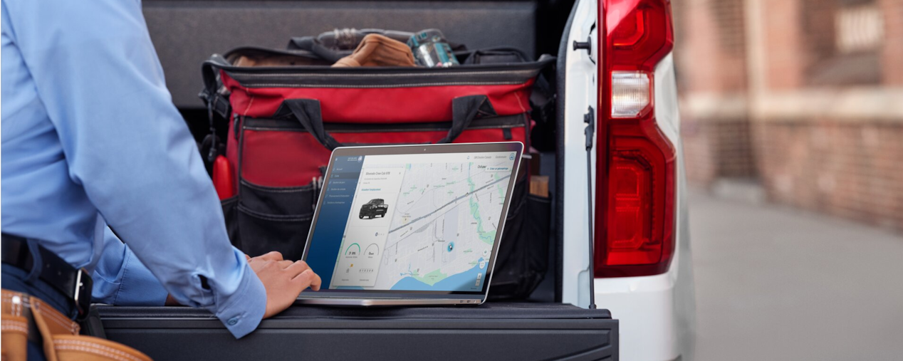 Une personne accédant à des informations en temps réel sur un véhicule Parcs GM depuis un ordinateur portable.